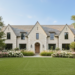 modern traditional french inspired house with light limestone stone exterior, steep gables, black steel windows, arched entry, manicured garden and formal lawn