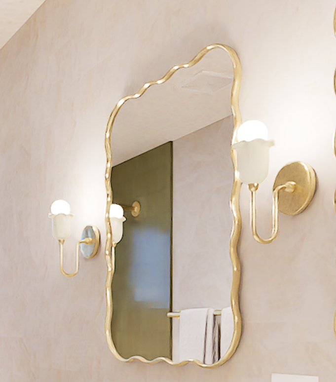 A decorative wall mirror with a softly wavy gold frame hangs between two matching brass sconces with frosted glass shades. The composition centers on the mirror’s reflective surface, which shows a muted door and a folded towel, while the pale textured wall and warm lighting create a calm, refined interior, as seen in AI in my design work. Home Design, Rendering, Annilee Waterman, Dallas Texas